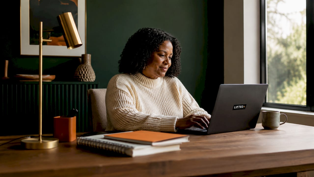Woman working at desk with teal accent wall