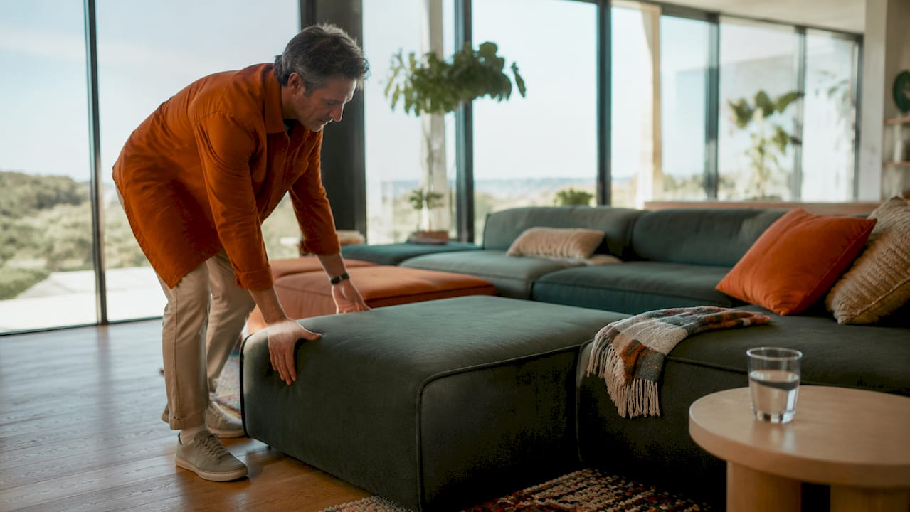 How interior design affects mental wellbeing 2 Man arranging furniture in spacious living room layout