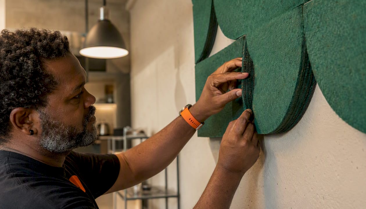 Top sculptural wall art for renters: no-drill feature walls 2 Hands fixing orange felt wall panel