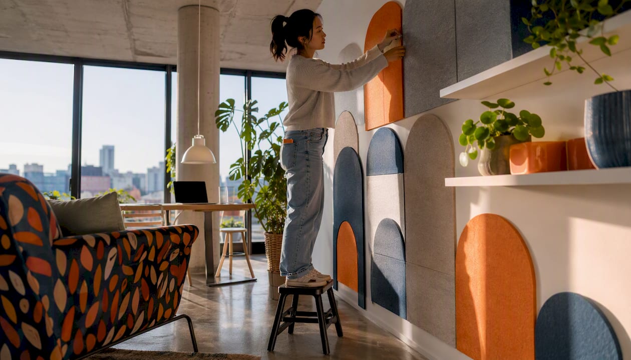 Woman installing colorful PET felt wall panels