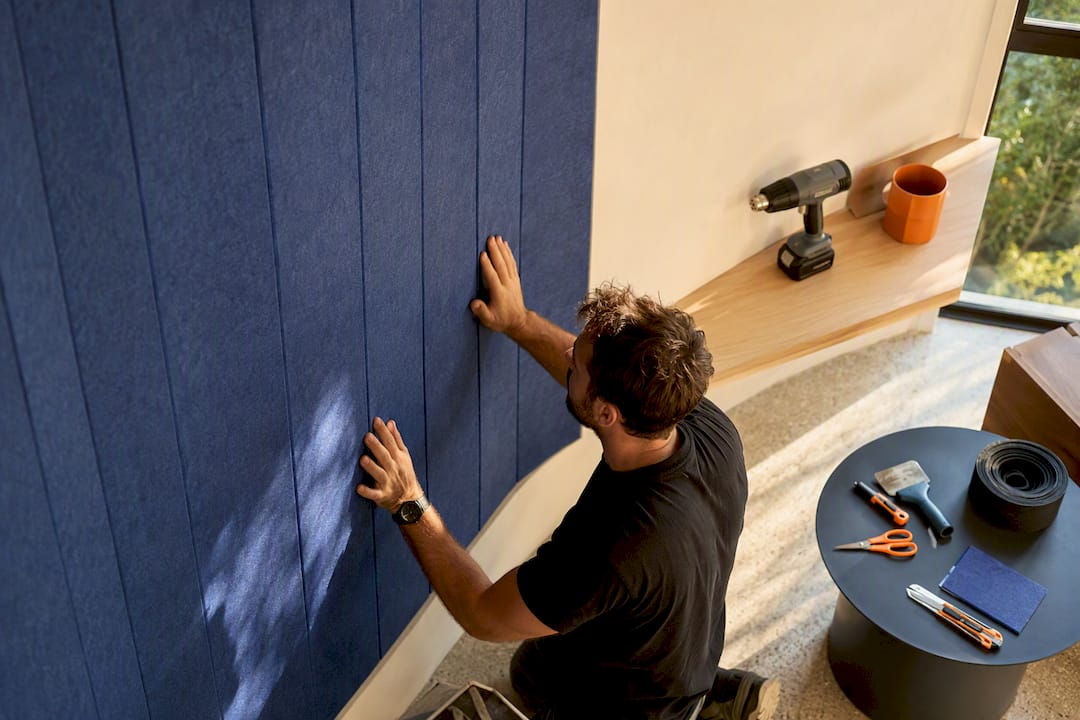 Hands pressing felt panel on curved wall